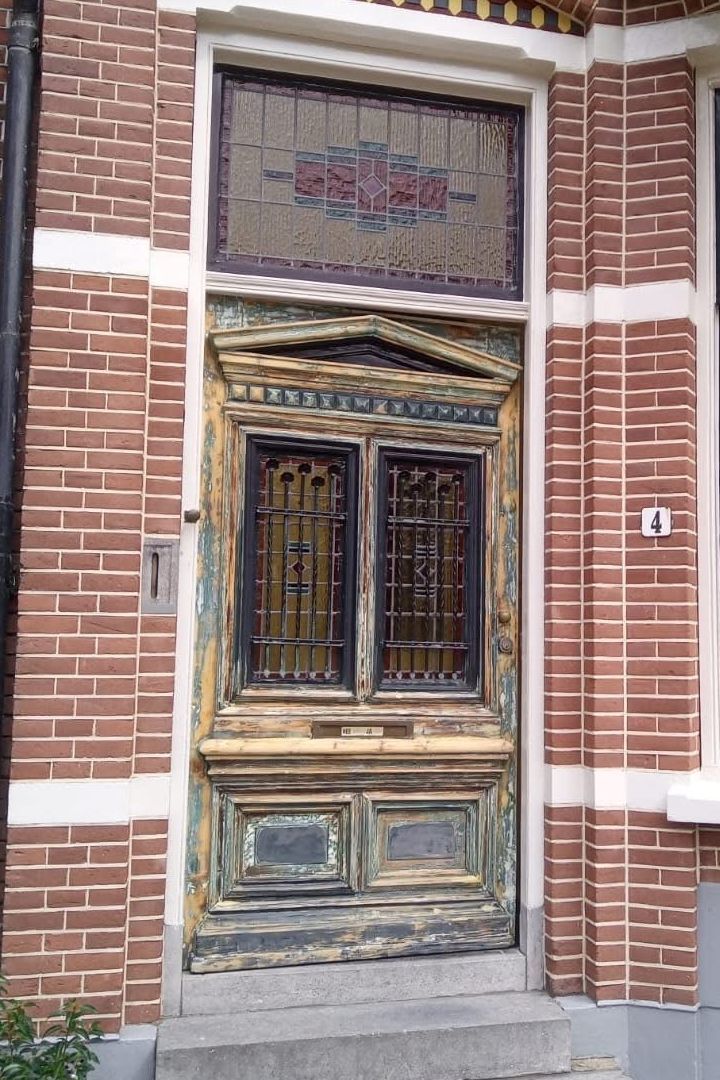 Voor: monumentale voordeur met verweerde verf