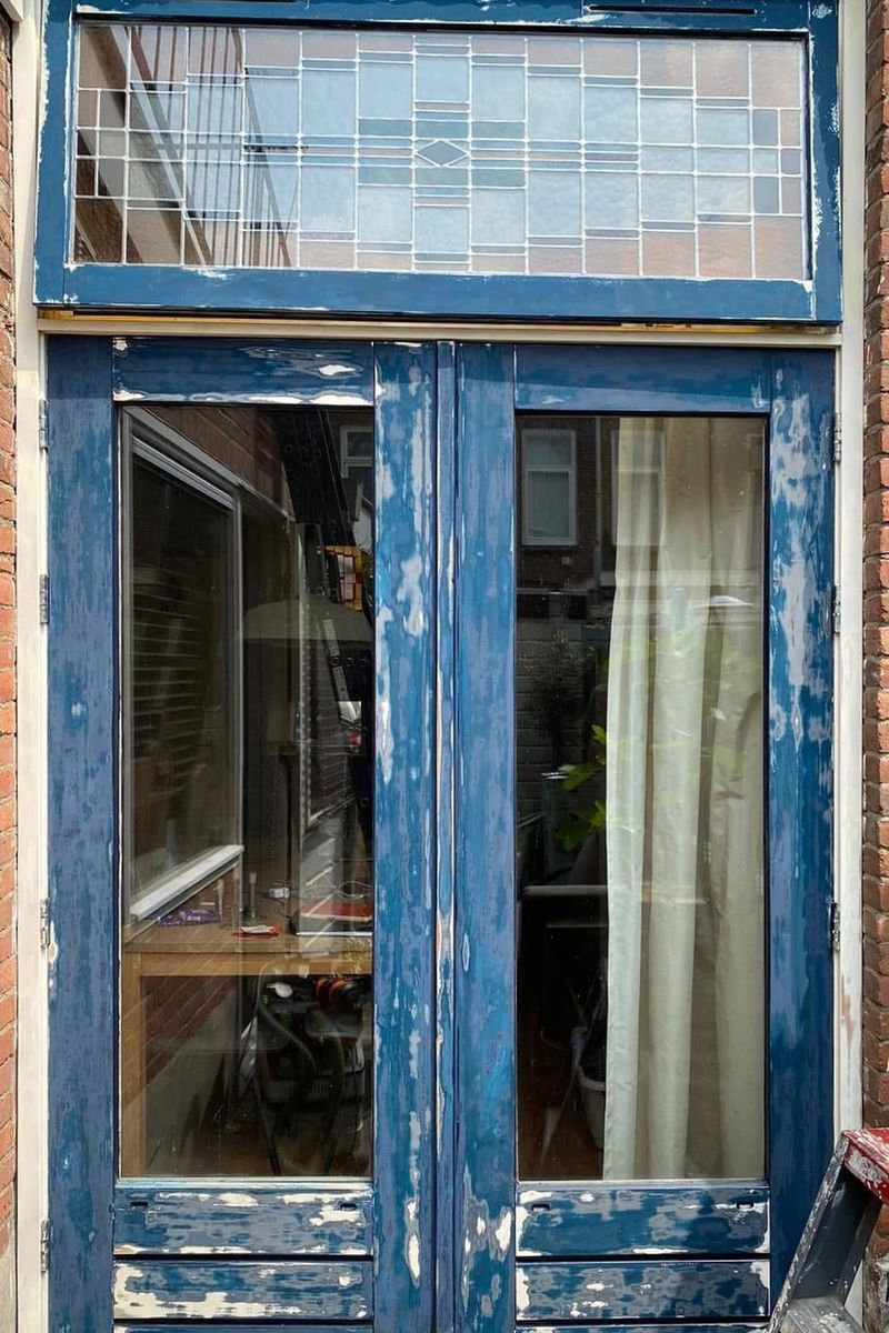 Voor: tuindeuren en bovenlicht met afgebladderde verf