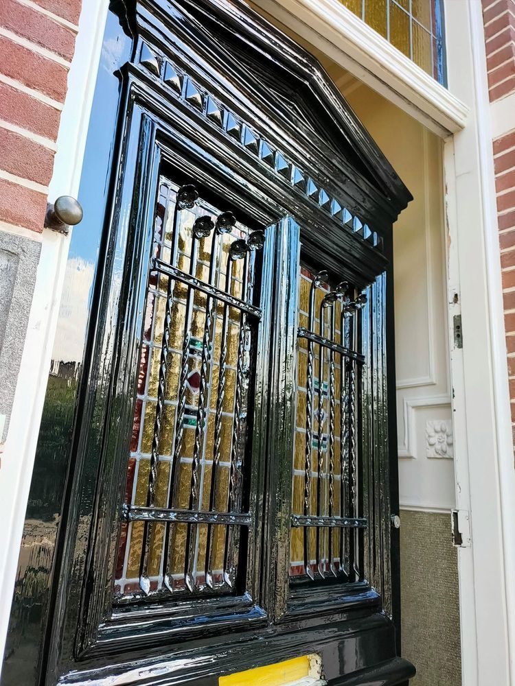 Voordeur in hoogglans met glas-in-lood en smeedijzer